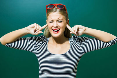 Smiling woman wearing striped shirt and sunglasses against green background, expressing happiness and confidence.